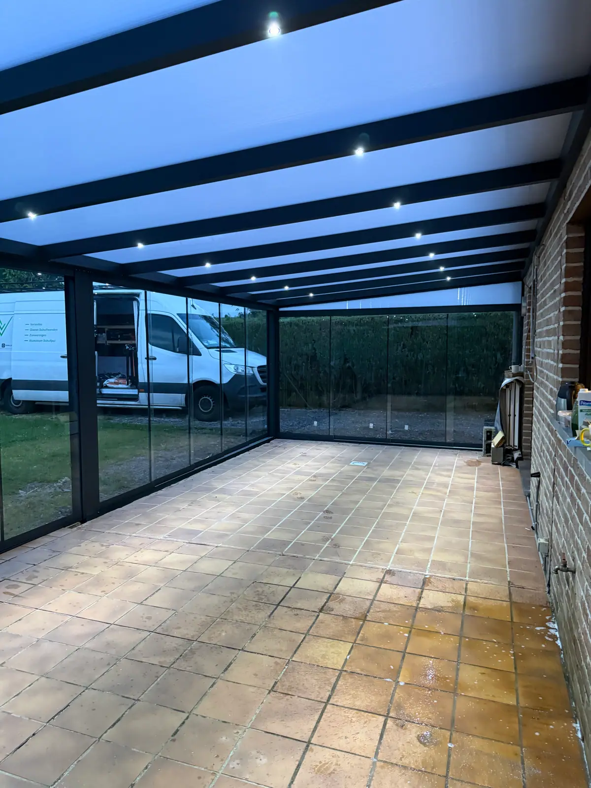 Dezelfde veranda later die avond, van binnenuit, met de ingebouwde verlichting aan