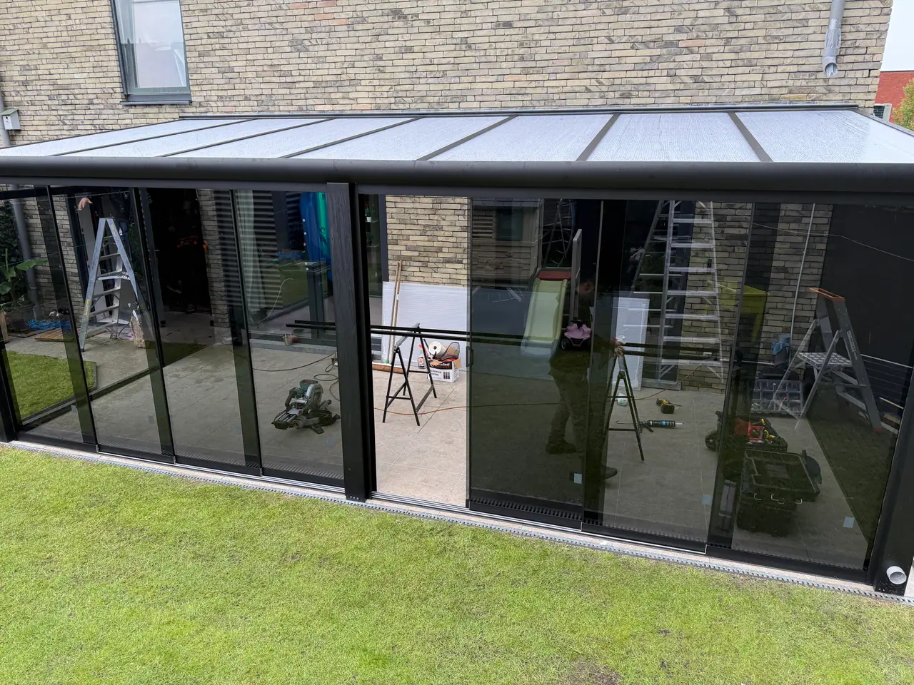 Monteur van SAVA Glass plaatst een glazen schuifwand bij een klant thuis